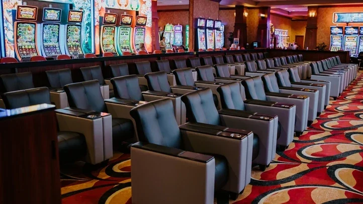 Seating facing illuminated slot machines on the casino floor.