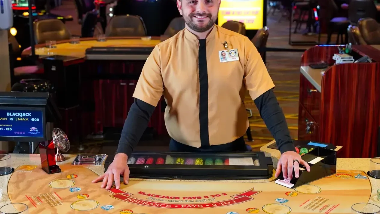 Blackjack dealer on the gaming floor at Tortoise Rock Casino.